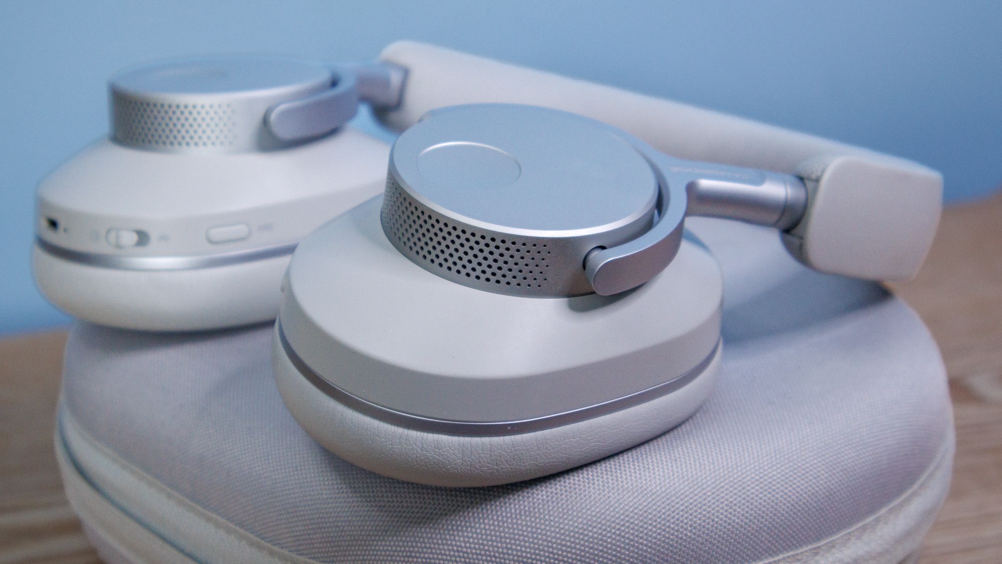 Cambridge Audio Melomania P100 SE kabellose Kopfhörer und Ladecase auf einem Holztisch