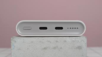 Close-up of ports on Samsung 25W 10,000mAh Wireless Battery Pack, on plinth on desk with pink background