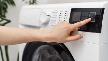 Personne démarrant une machine à laver