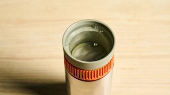 Cafeteira portátil Wacaco Pipamoka exibida sobre um fundo azul sólido