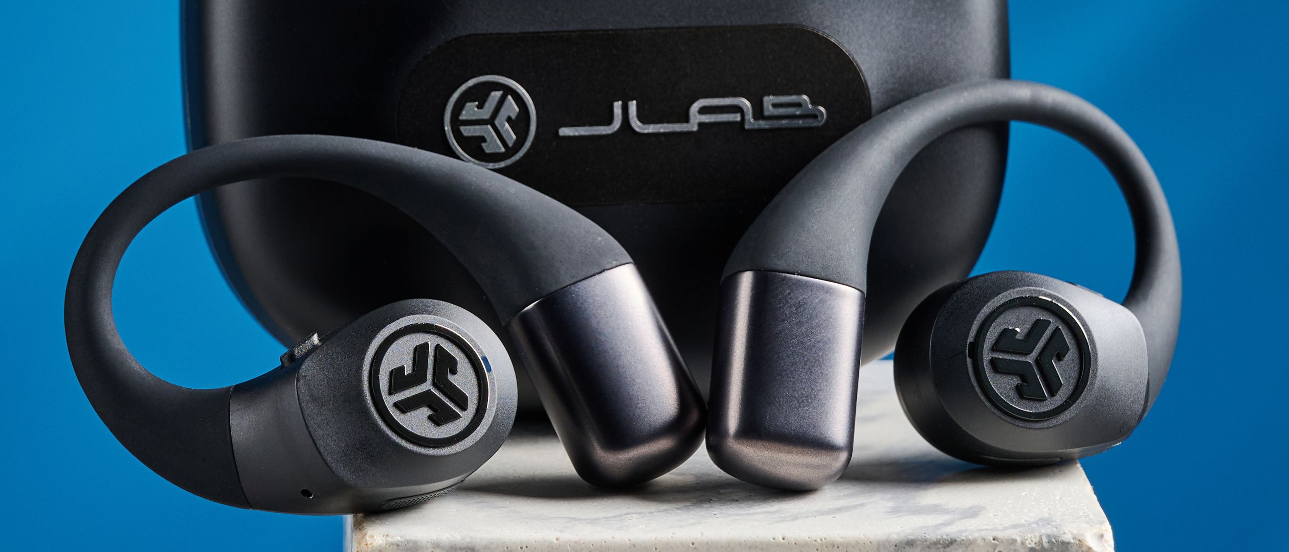 Jlab Epic Open Sport Open-Ear-Kopfhörer in Schwarz auf blauem Hintergrund