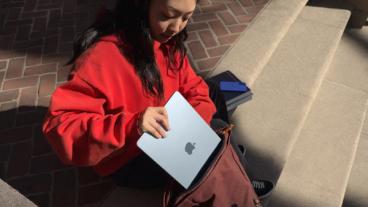 En person lægger en MacBook Air M4-bærbar computer ned i en taske