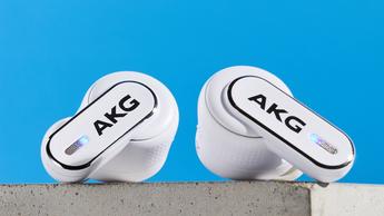 Ein Paar weiße AKG N5 Hybrid-Ohrhörer von Harman in ihrem Ladeetui mit Zubehör