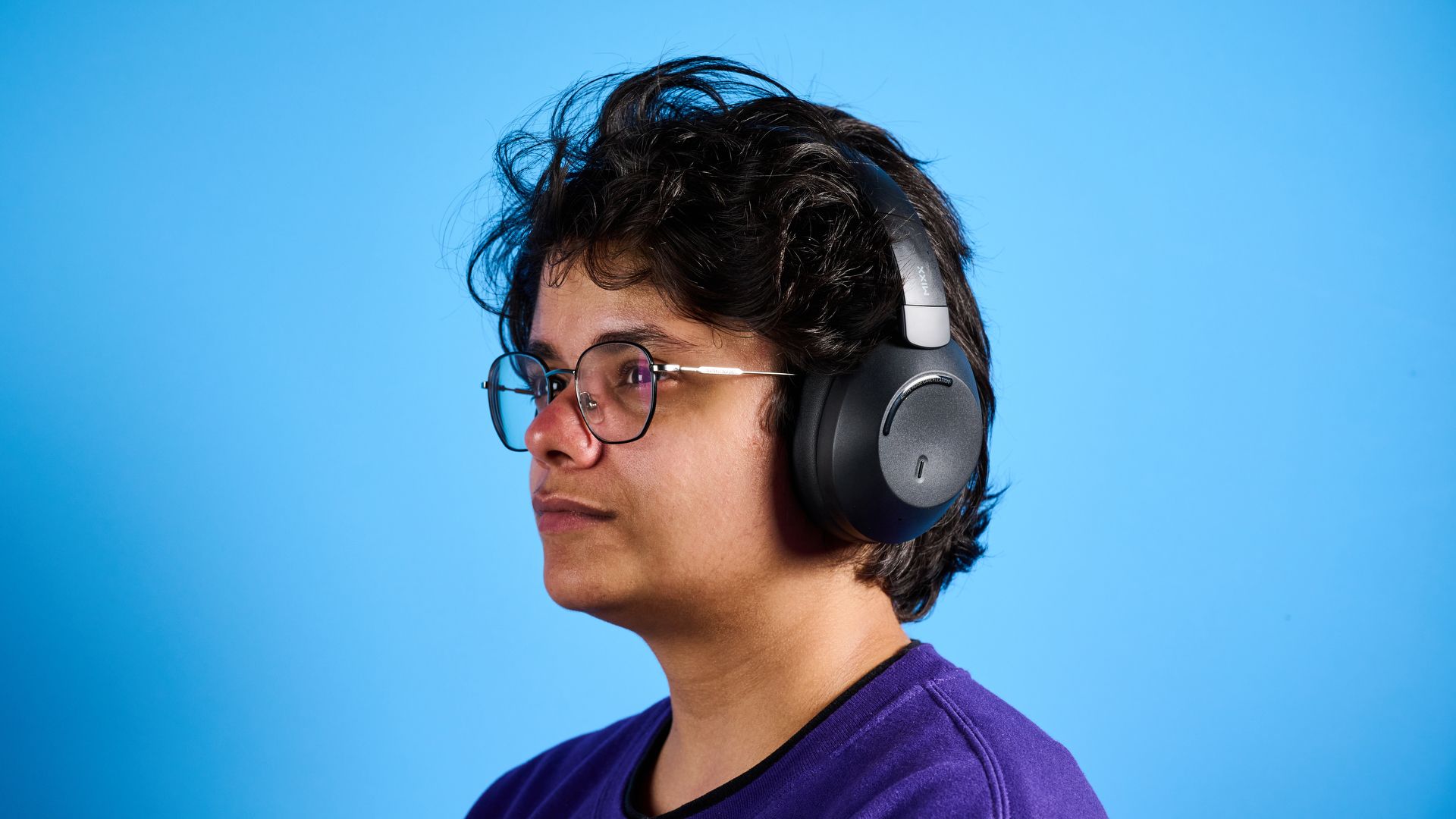 Mixx StreamQ C4 kabellose Kopfhörer in Schwarz mit weichen Ohrpolstern und Tastensteuerung vor blauem Hintergrund