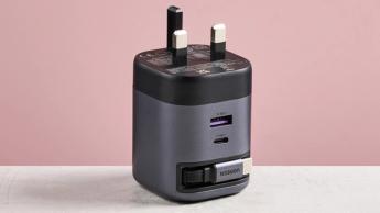 Ugreen Nexode 65W oplader med indtrækkeligt USB-C-kabel, vist på et bord med lyserød baggrund