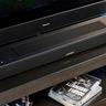 Die schwarze Bose Smart Soundbar 2024 mit Fernbedienung, ausgestattet mit zwei Touch-Bedienelementen und einer Netzabdeckung