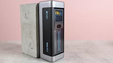 Cuktech 20 batería externa descansando sobre un pedestal en un escritorio con fondo rosa