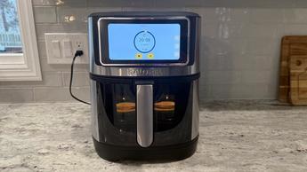 Una freidora de aire Kalorik Vivid Touch con pantalla táctil cocinando alimentos sobre una encimera de cocina