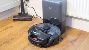 Aspiradora robot Eufy E20 acoplada con accesorio para el suelo cercano