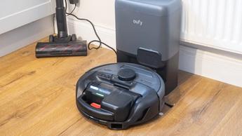 Aspirapolvere robot Eufy E20 in carica con accessorio per pavimenti vicino