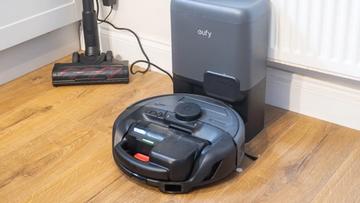 Aspiradora robot Eufy E20 acoplada con accesorio para el suelo cercano