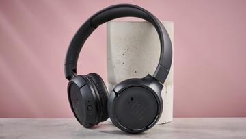 JBL Tune 510BT trådløse hovedtelefoner hvilende mod en søjle på en lyserød baggrund