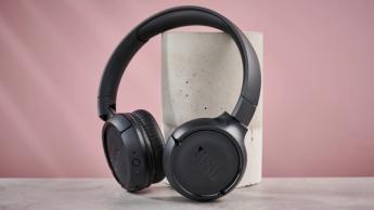 Fones de ouvido sem fio JBL Tune 510BT sobre uma coluna com fundo rosa