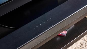 the sony ht-s100f or sony ht-sf150 in uk, a black soundbar with buttons on the top, a remote, photographed with a panasonic TV