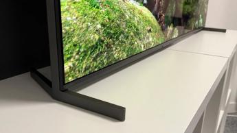 Крупный план подставки 55-дюймового телевизора Sony Bravia 8 II QD-OLED. На экране — документальный фильм о природе. Телевизор стоит на белом столе.
