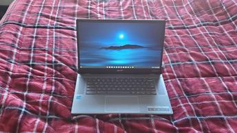 En Chromebook Plus-laptop på en säng