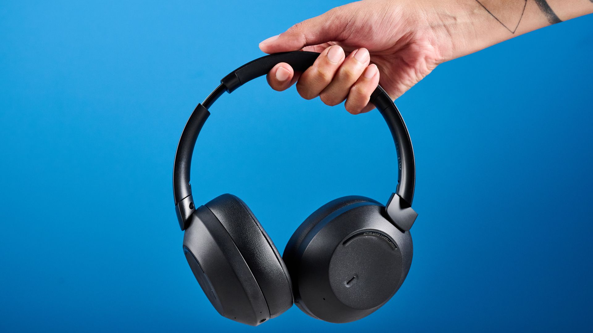 Mixx StreamQ C4 kabellose Kopfhörer in Schwarz mit weichen Ohrpolstern und Bedientasten vor blauem Hintergrund