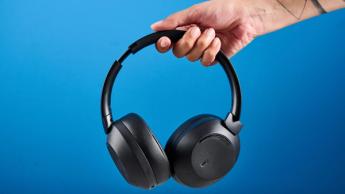 Mixx StreamQ C4 kabellose Kopfhörer in Schwarz mit weichen Ohrpolstern und Bedientasten vor blauem Hintergrund