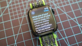 Et Apple Watch SE med en grøn og grå stofrem, der viser den nye Vitals-app på skærmen