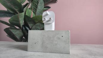 Carregador de parede Belkin BoostCharge USB-C de 67W com três portas exibido sobre uma superfície rosa