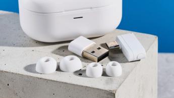 Die weißen AKG N5 Hybrid-Ohrhörer von Harman, präsentiert in ihrem Ladecase mit enthaltenem Zubehör