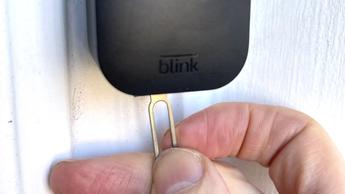 Persona usando una herramienta para abrir un videoportero Blink