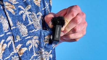 Das Rode Wireless GO Gen 3 Mikrofon-Set mit einem Empfänger, zwei Sendern und Zubehör wie Windschutz, Ladekabeln und Adaptern vor blauem Hintergrund