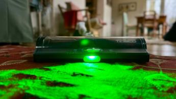 Aspiradora inalámbrica tipo escoba Tineco Pure One A50S con cabezal iluminado en verde mostrando el polvo detectado