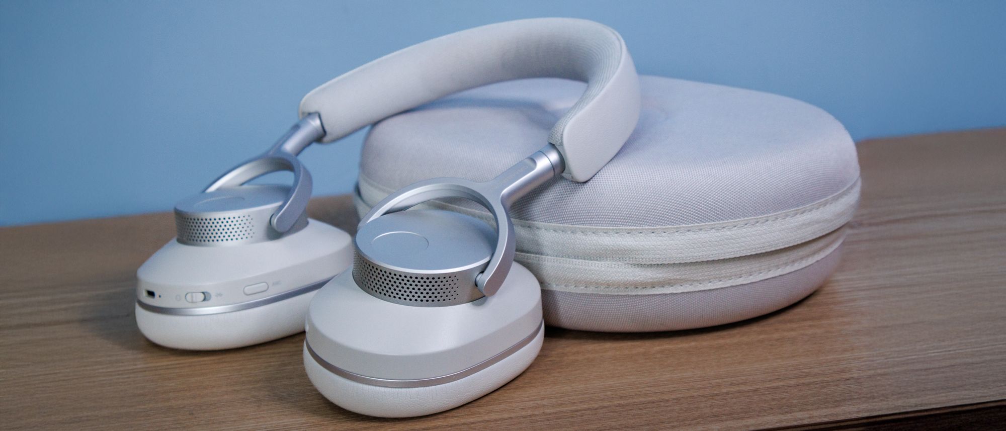 Cambridge Audio Melomania P100 SE kabellose Kopfhörer und Ladecase auf einem Holztisch