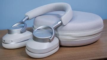 Cambridge Audio Melomania P100 SE kabellose Kopfhörer und Ladecase auf einem Holztisch