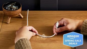 Persona organizando cables con ganchos transparentes Command