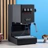 La macchina per espresso Gaggia Classic E24 Evo Pro con accessori inclusi esposta su un piano in pietra e sfondo blu