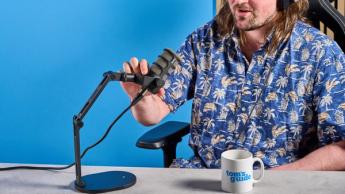 Das Rode PodMic Podcast- und Broadcast-Mikrofon auf blauem Hintergrund mit dem Rode DS2 Tischstativ