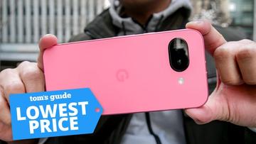 Google Pixel 9a-smartphone holdt i hånden med et mærke for laveste pris synligt