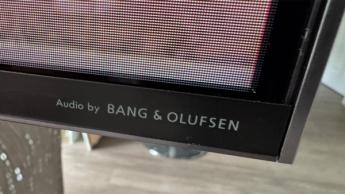 Крупный план угла телевизора TCL 98C7K диагональю 98 дюймов с логотипом Bang & Olufsen