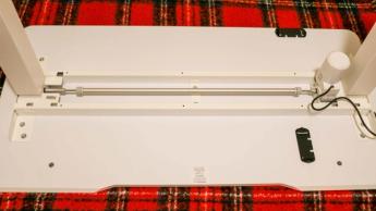 La parte inferior del escritorio elevable eléctrico Vari Essential mostrando el sistema de motor único y barra de conexión