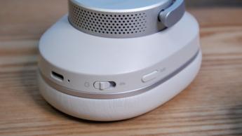 Nahaufnahme des Bedienknopfs und der Taste für aktive Geräuschunterdrückung an den kabellosen Cambridge Audio Melomania P100 SE Kopfhörern