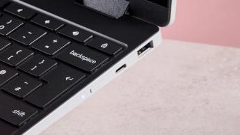 Närbild av Samsung Galaxy Chromebook 2 360:s portar på höger sida på ett skrivbord med rosa bakgrund