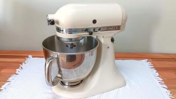 Batidora de pedestal KitchenAid Artisan color crema almendra sobre una encimera de cocina