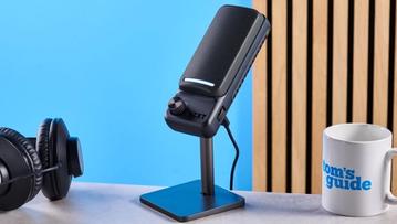 Das NZXT Capsule Elite Gaming-Mikrofon in Schwarz mit Nierenkondensator-Design, vor blauem Hintergrund gezeigt, mit zwei Bedienelementen und RGB-LED-Panels