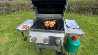 Un pollo a la parrilla en una barbacoa Weber Spirit II E-310