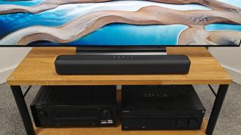 Саундбар Amazon Fire TV, установленный на деревянной стойке под телевизором, вид под углом сверху