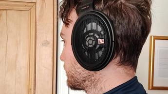 Et medlem af TechRadar-teamet iført Sennheiser HD-660S2-hovedtelefoner står foran en trædør