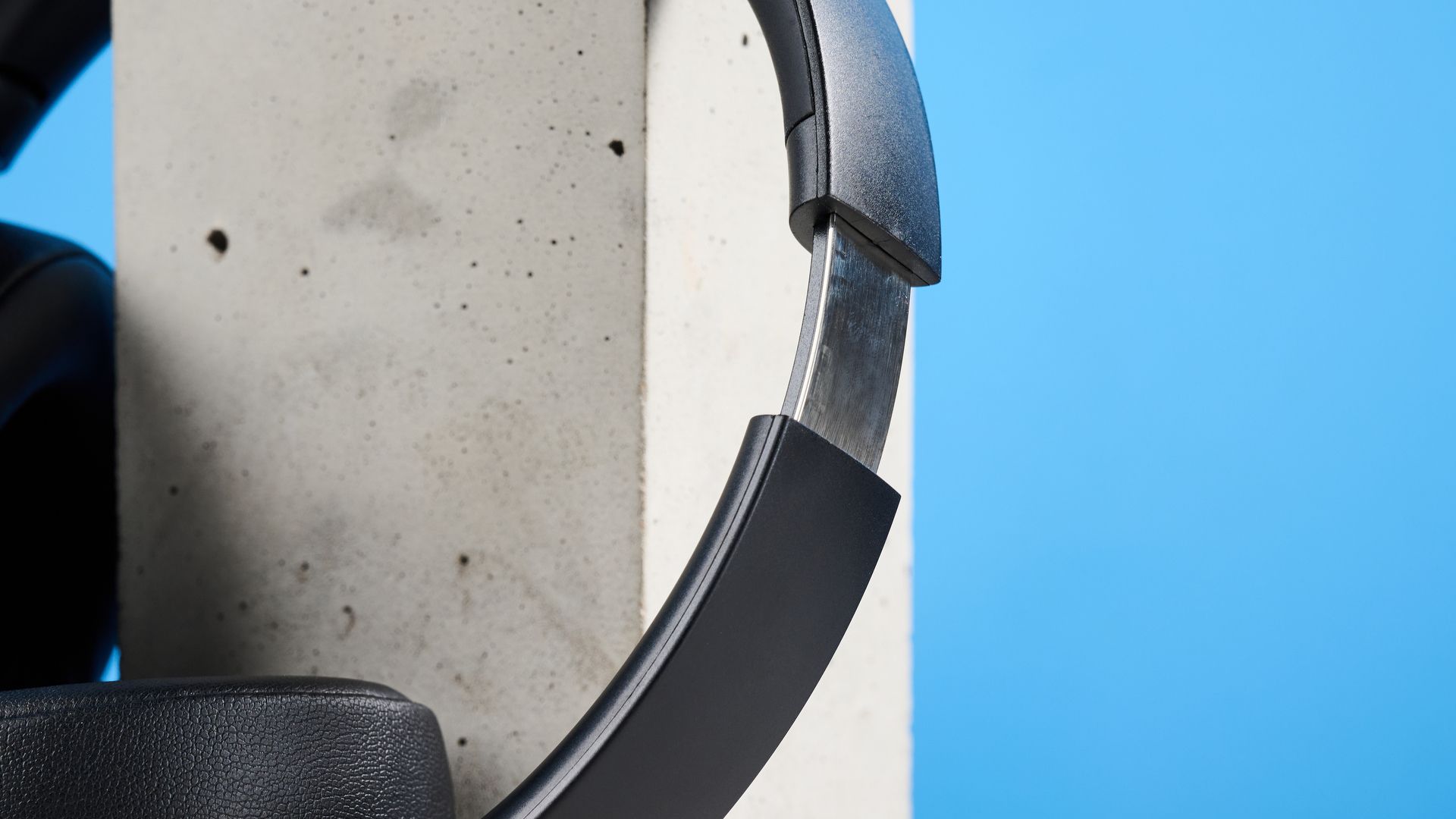 Mixx StreamQ C4 kabellose Kopfhörer in Schwarz mit weichen Ohrpolstern und sichtbaren Bedientasten vor blauem Hintergrund