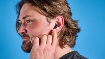 Schwarz-blaue H2O Audio Ript-Lite Ohrhörer auf blauem Hintergrund, für Workouts und täglichen Musikgenuss entwickelt