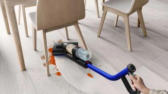 La aspiradora Dyson WashG1 limpiando el polvo debajo de una mesa