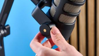 Rode PodMic Podcast-Mikrofon auf blauem Hintergrund mit Rode DS2 Tischstativ