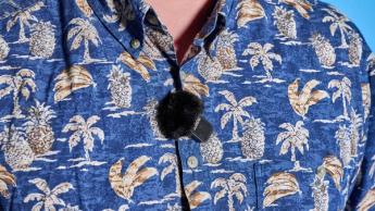 Das Rode Wireless-Mikrofonsystem mit schwarzem Ladecase und zwei schwarzen Sender-Mikrofonen auf blauem Hintergrund