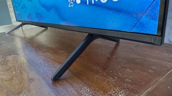 Смарт-телевизор TCL C6KS с диагональю 50 дюймов на деревянном столе: видна нижняя кромка и ножки-подставки телевизора