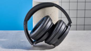 Schwarze kabellose Earfun Tune Pro Kopfhörer mit grauen Ohrmuscheln und weichem Kunstleder vor blauem Hintergrund